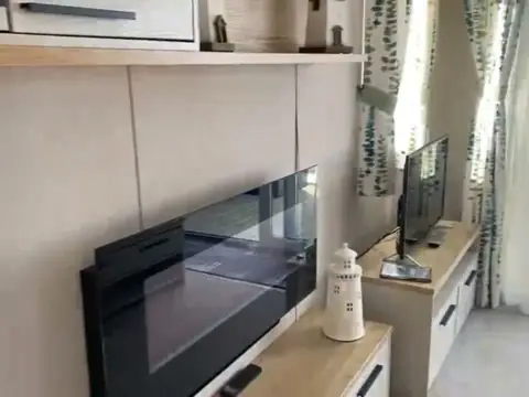 Lounge wall with an electric fire and a TV on a cabinet