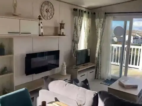 Lounge with an electric fire, TV and patio doors out to the decking