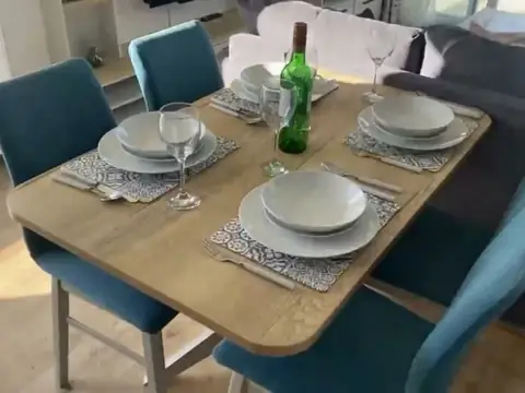 Dining table for four laid with plates and cutlery